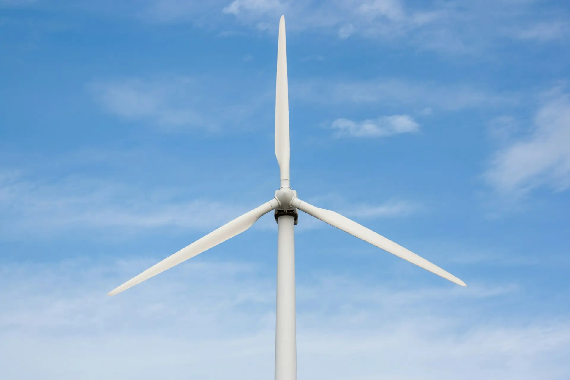 a white wind turbine against a blue sky